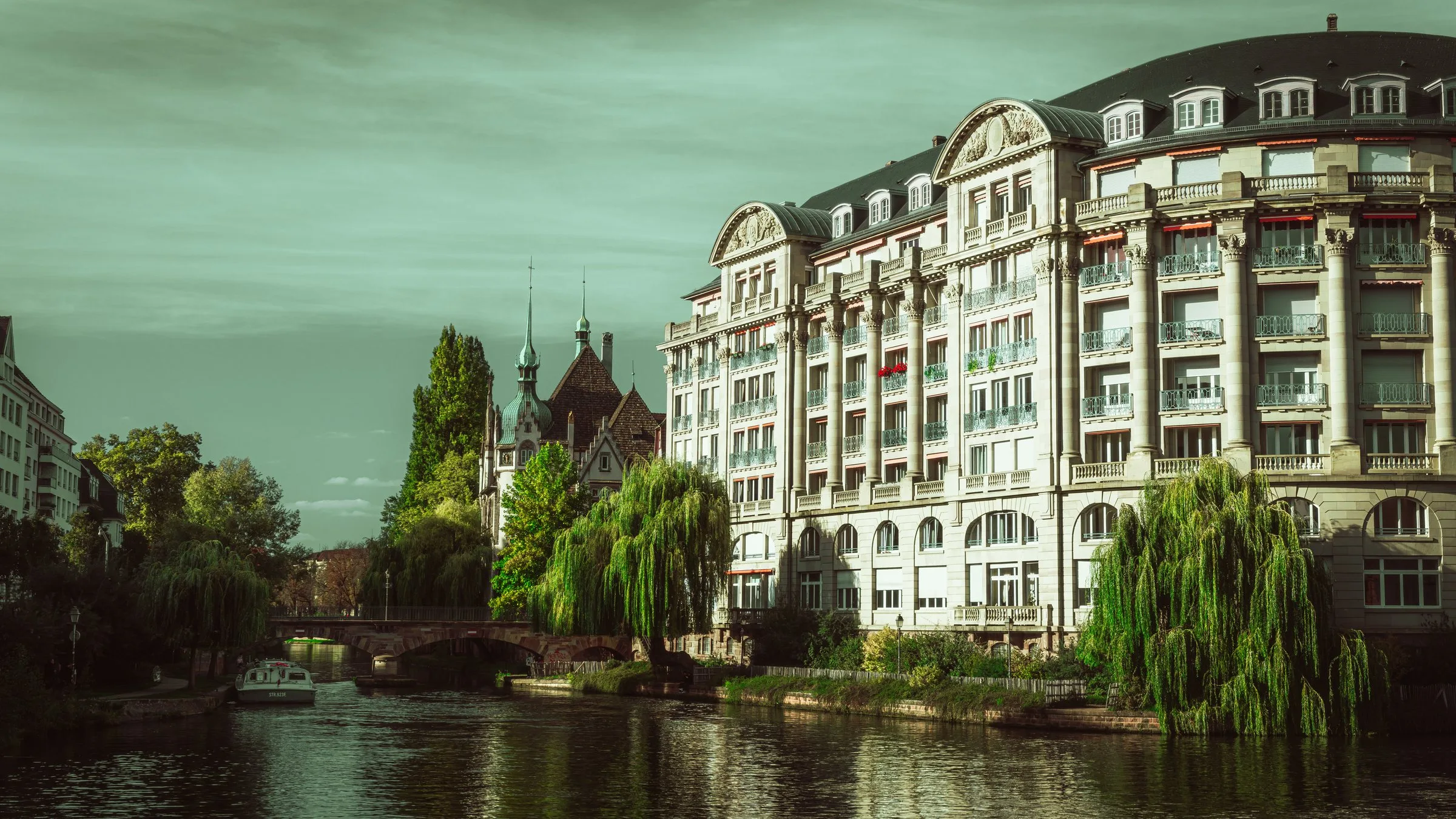Un grand hôtel au bord de l’eau, entre les saules