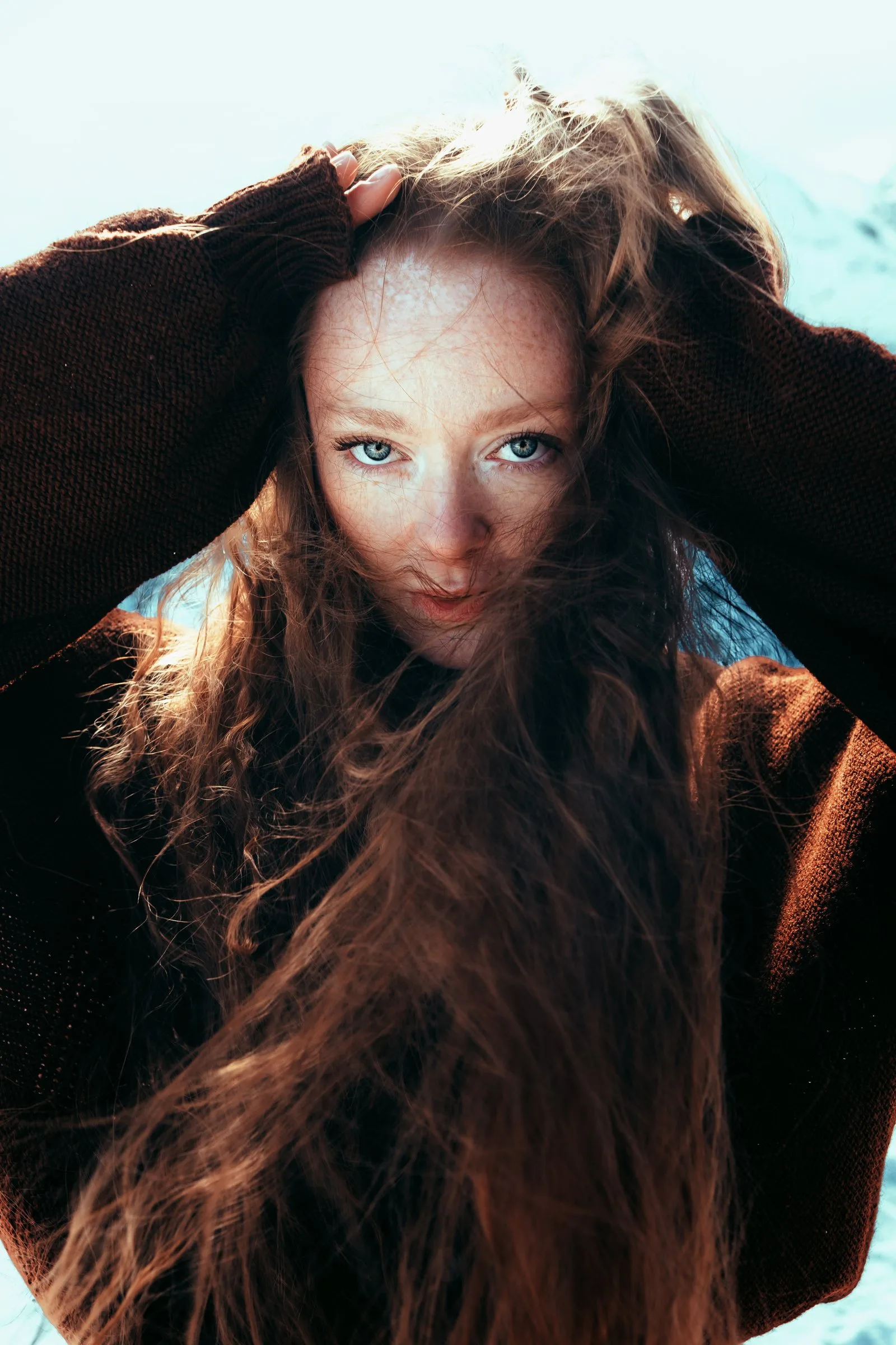 Cheveux roux au vent sous un ciel bleu