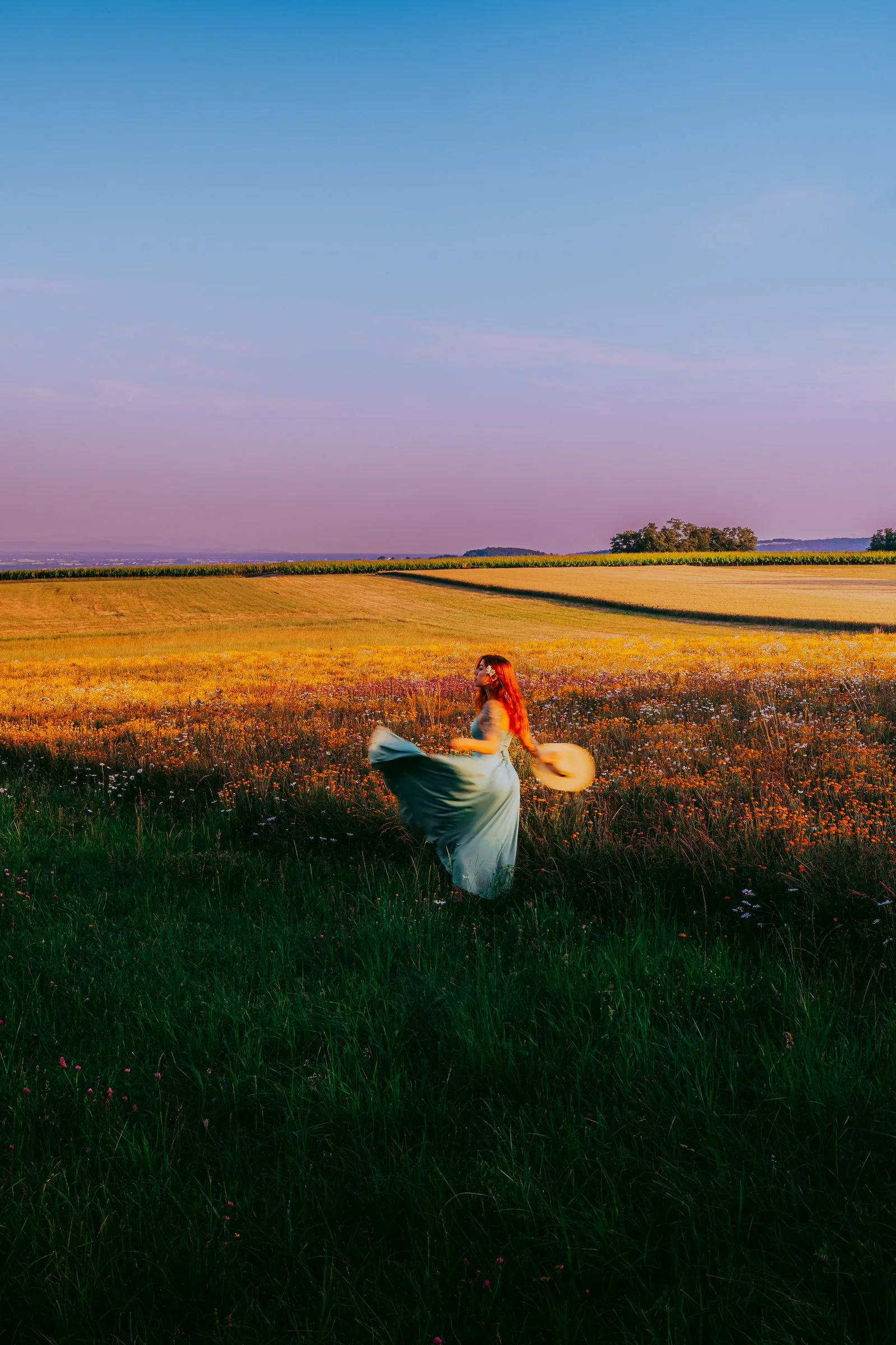 Femme en robe légère dans un champ au crépuscule