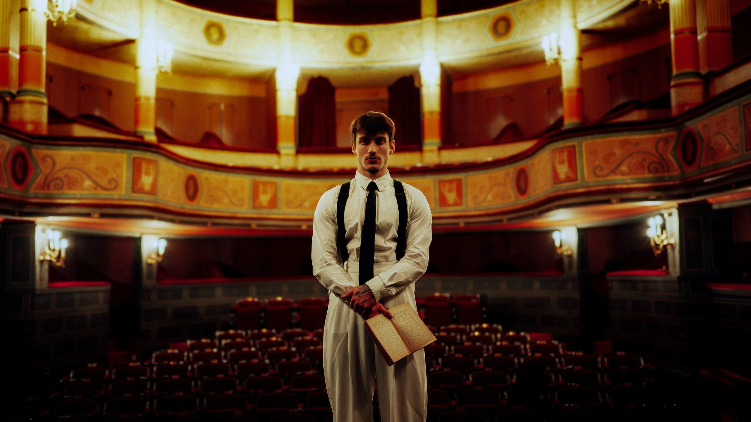 Homme en chemise blanche sur la scène d’un théâtre à l’italienne