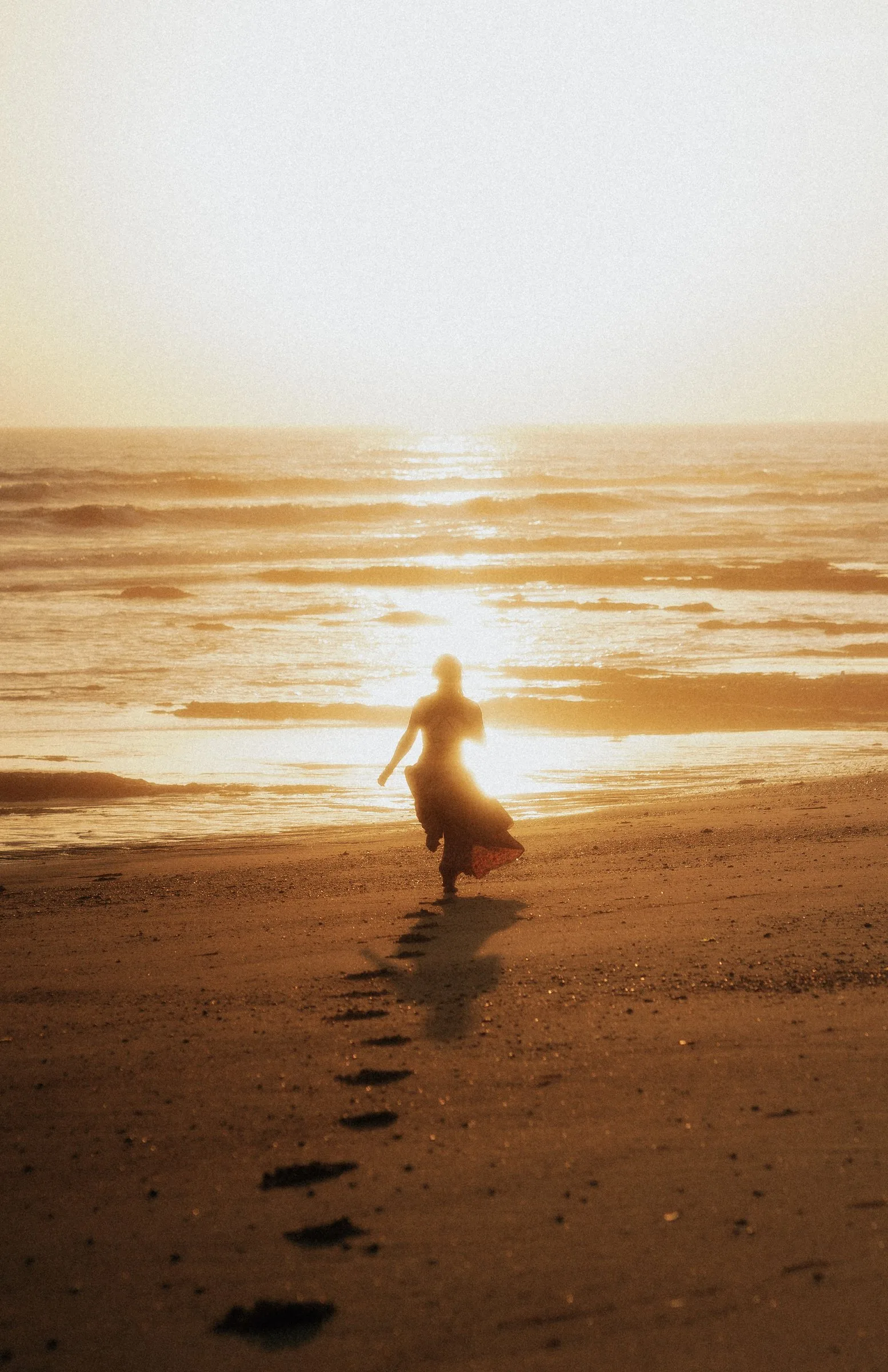 Silhouette qui marche vers le soleil couchant sur la plage