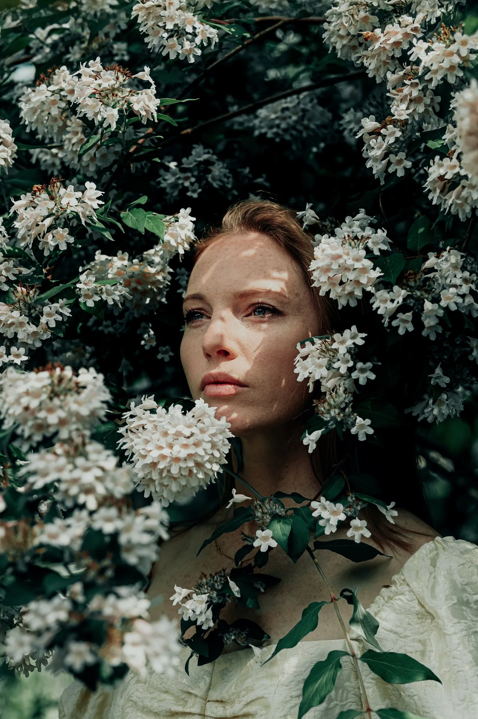 Visage entouré de fleurs blanches