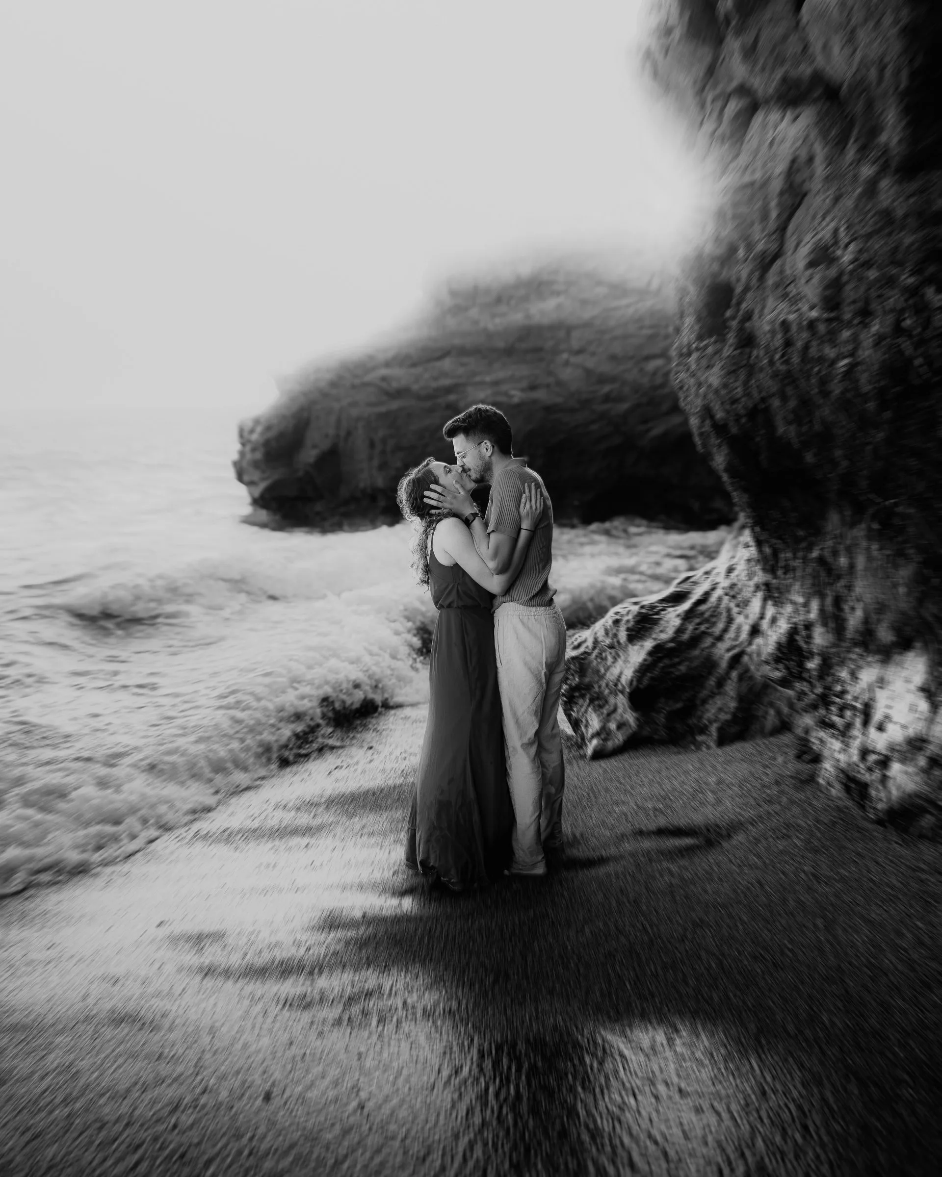 Couple enlacé face aux rochers, en noir et blanc