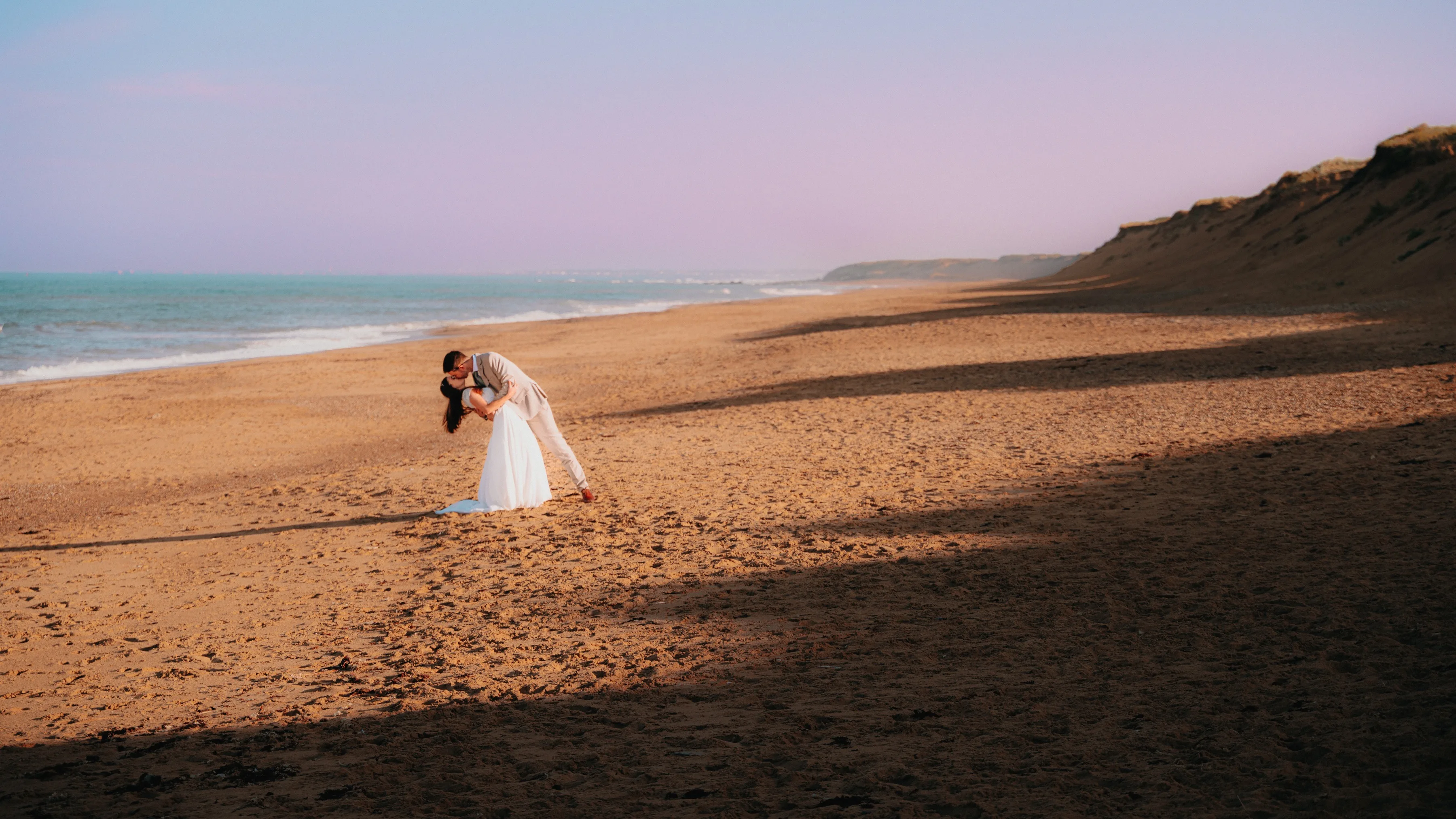 Le couple enlacé sur une grande plage au crépuscule