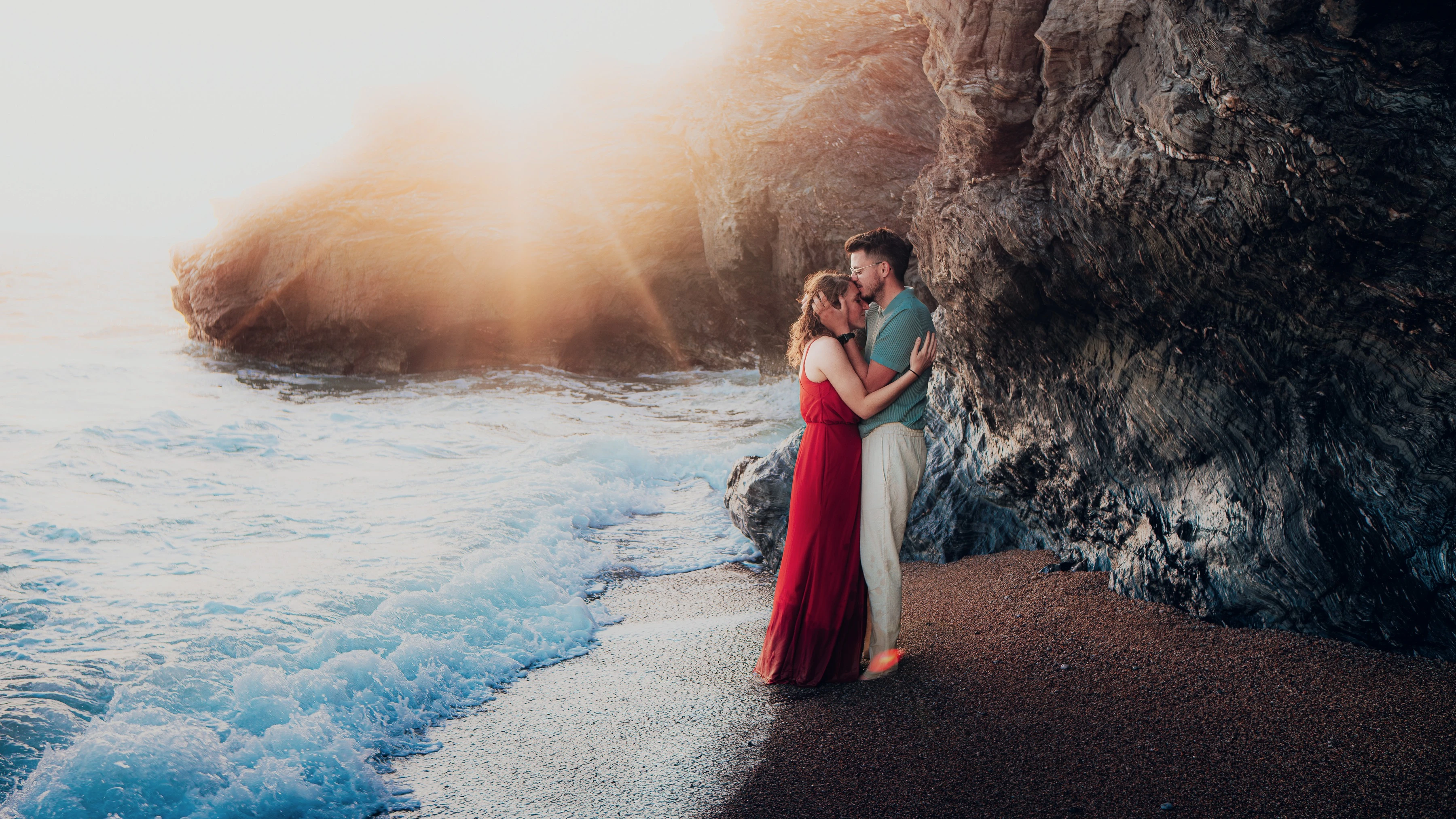 Couple enlacé au pied des rochers dans une crique de Saint-Gilles-Croix-de-Vie, au coucher du soleil