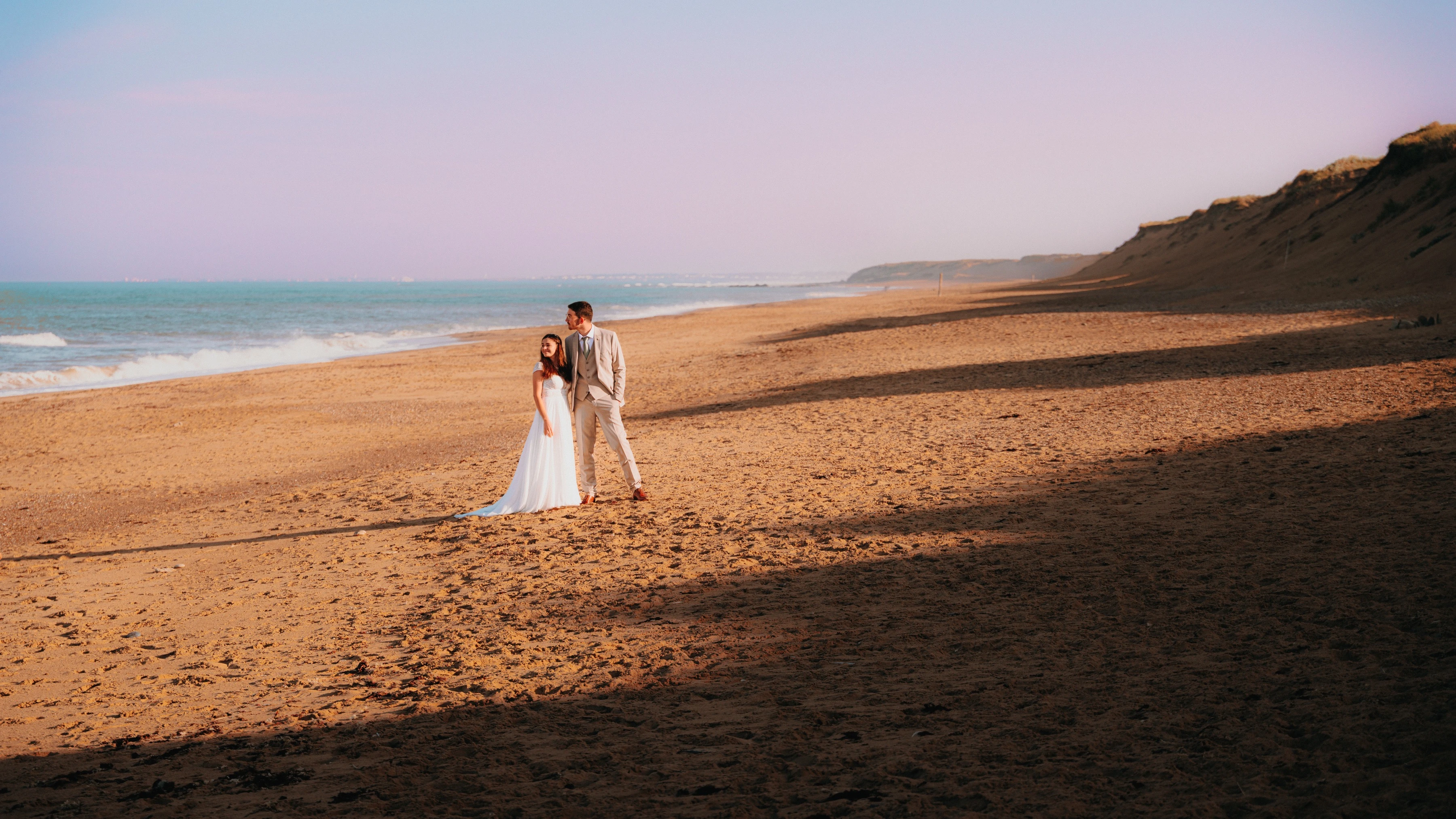 Le couple sur une grande plage au crépuscule