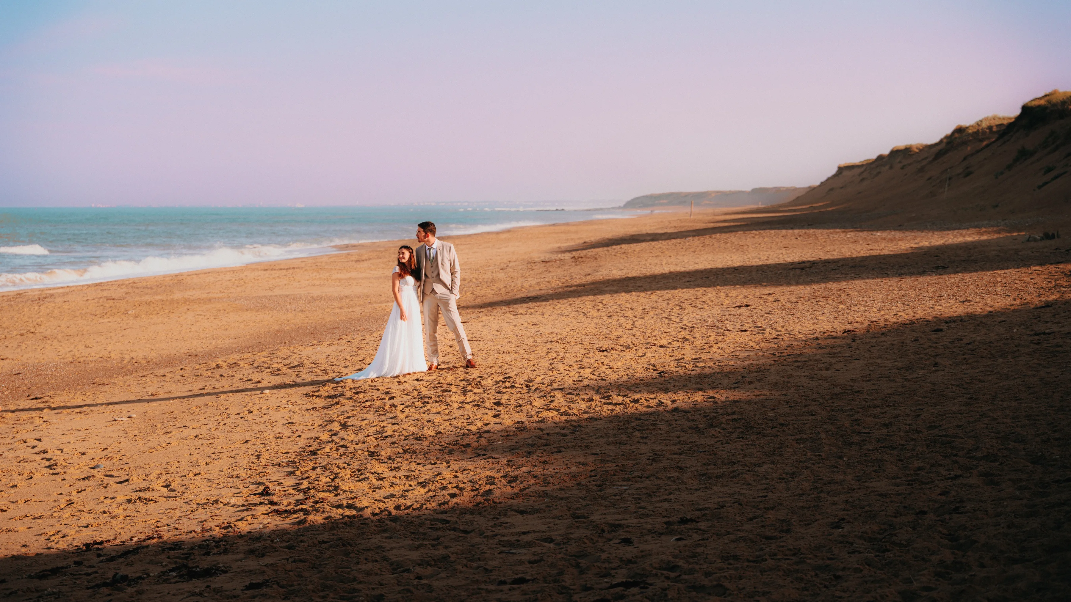 Le couple sur une grande plage au crépuscule
