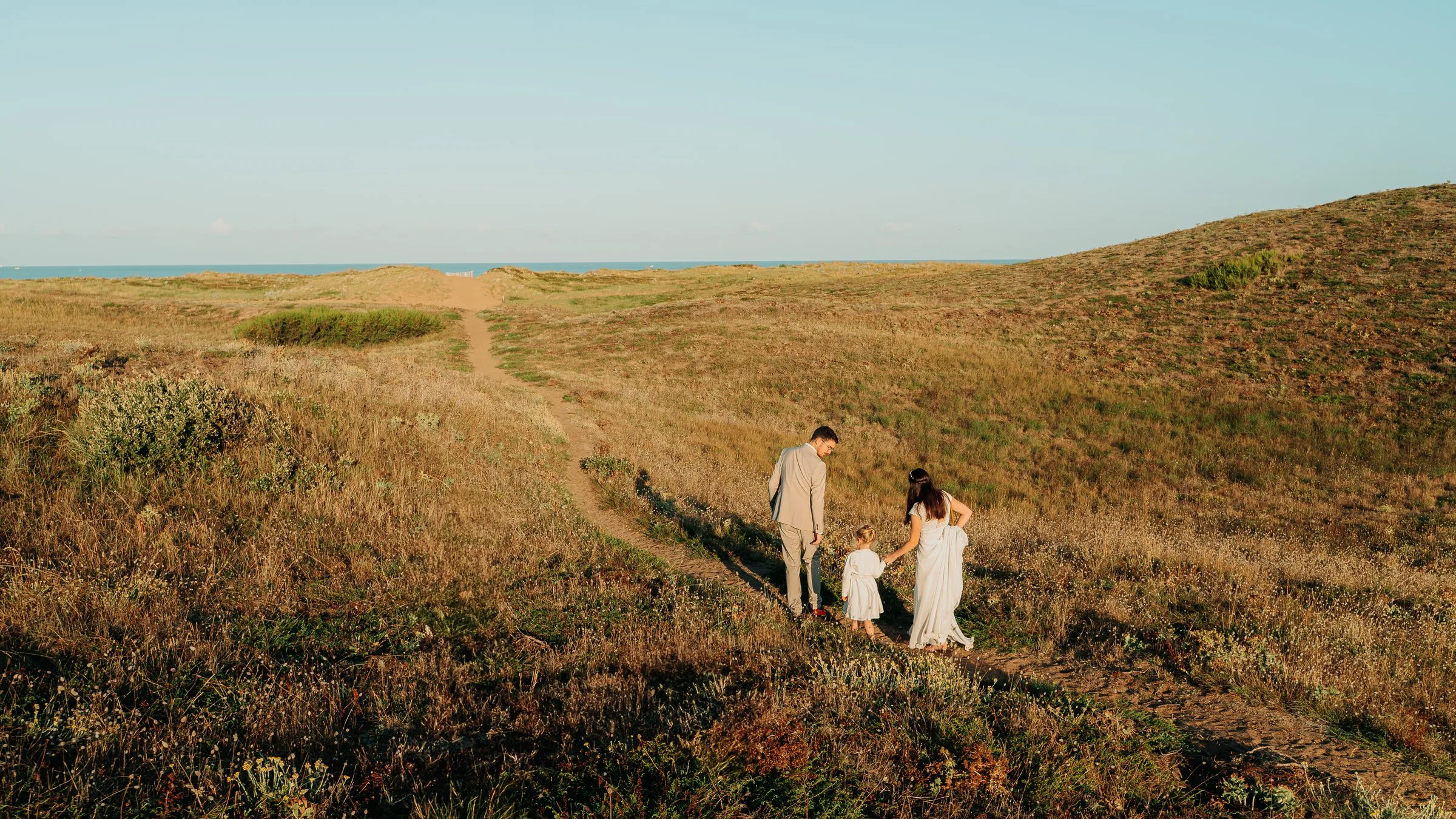 Couple en tenue de mariage dans les dunes