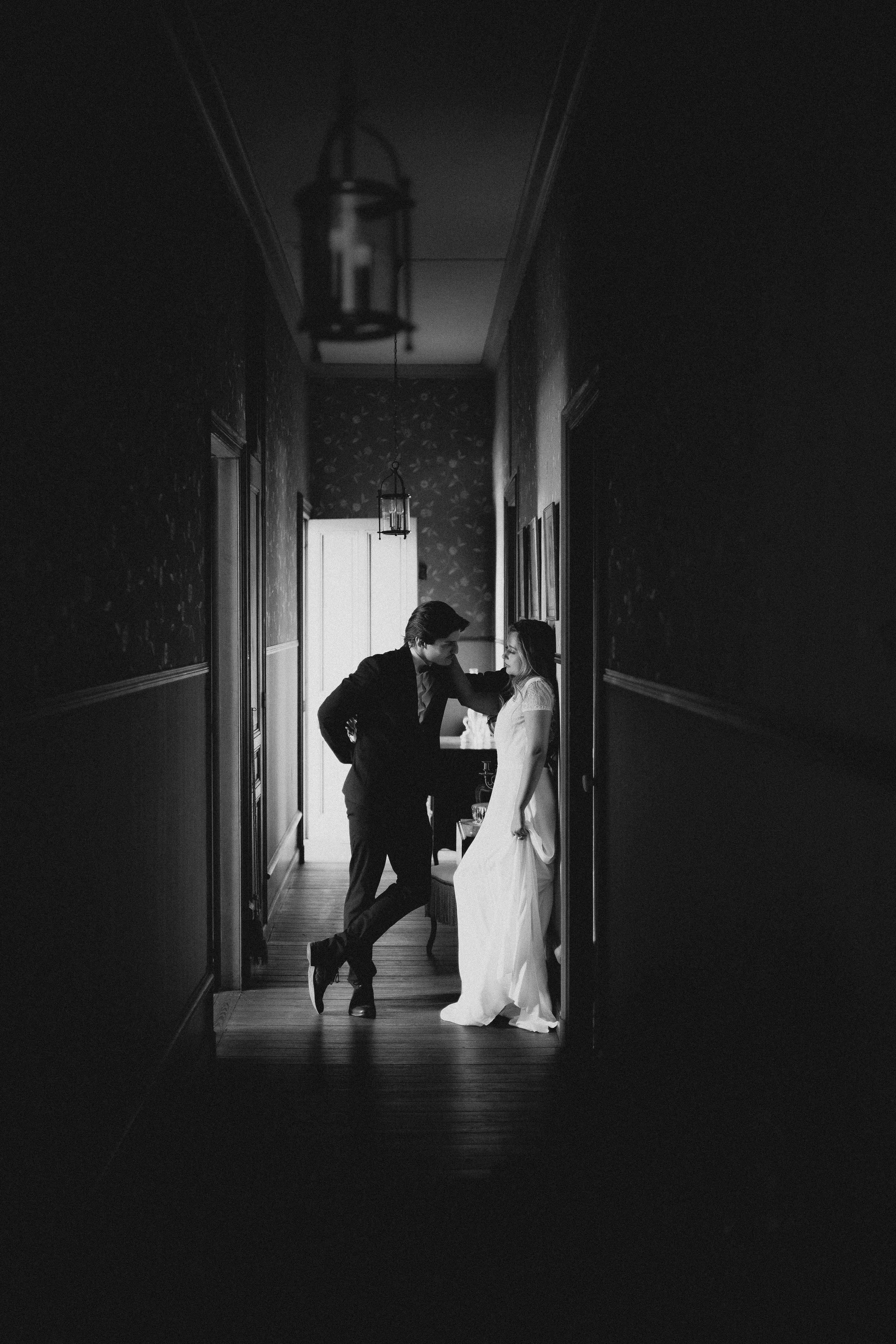 Les fiancés dans un long couloir sombre, en noir et blanc