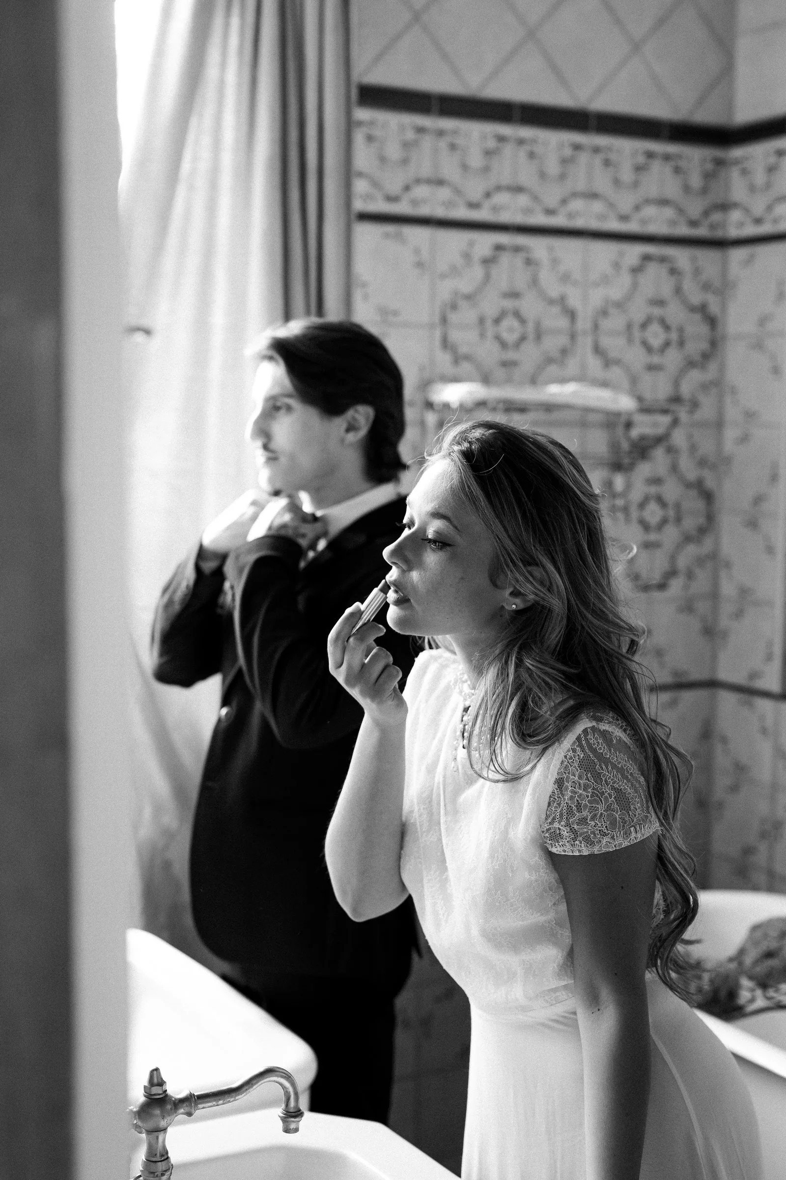 Les fiancés se préparent devant le miroir de la salle de bain, en noir et blanc