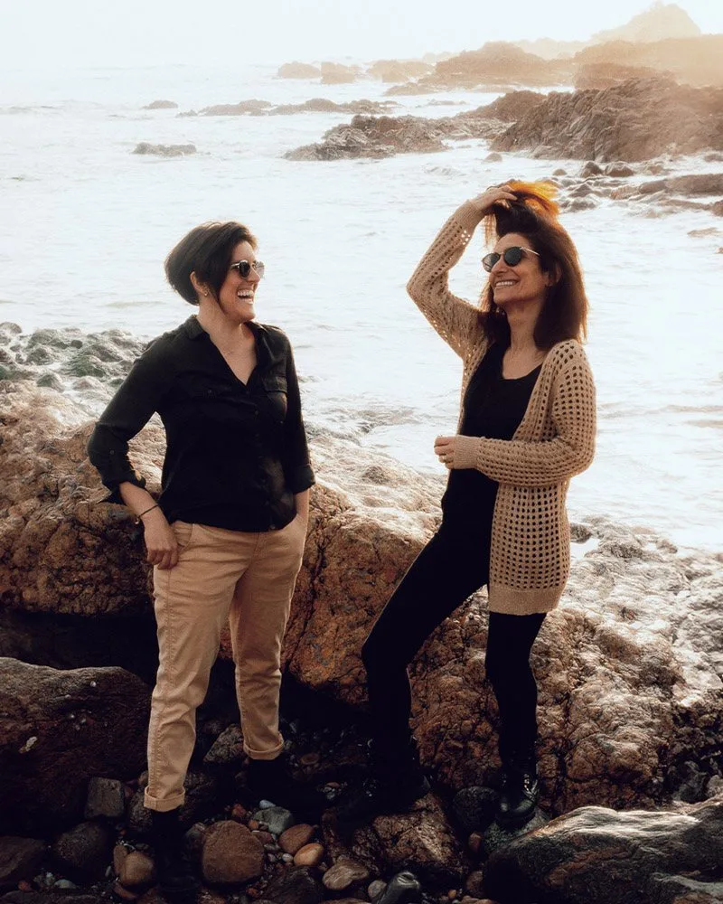 Deux femmes sur les rochers face à l’océan