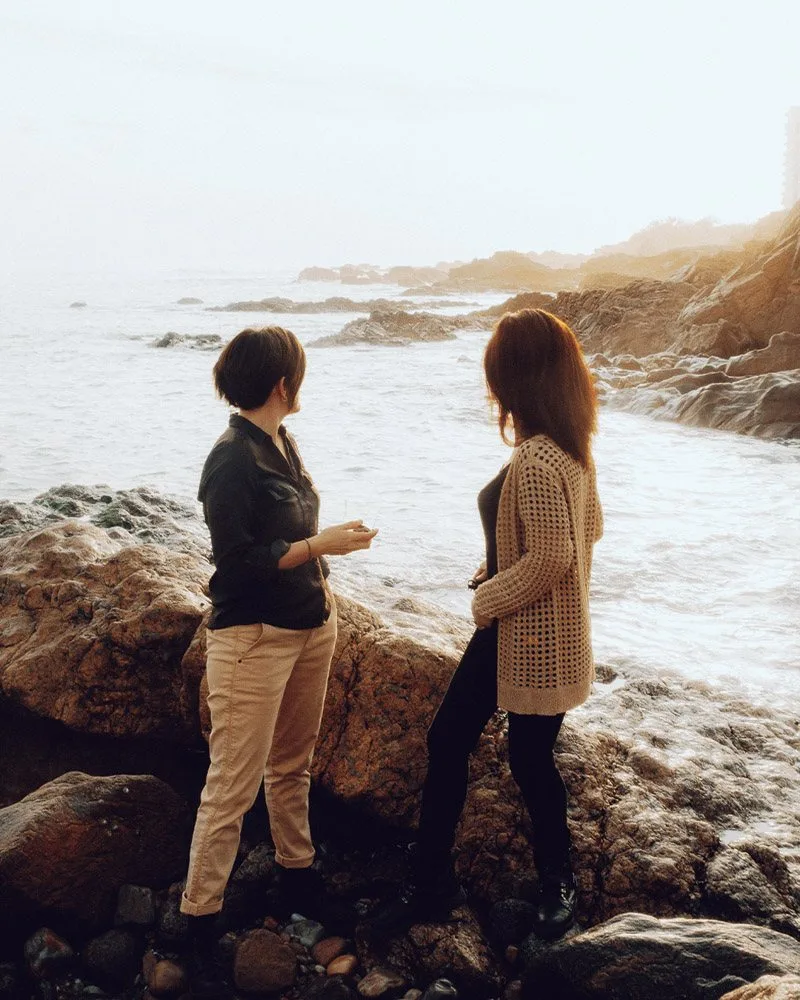 Mounira et Julie discutent sur les rochers, face à l’océan