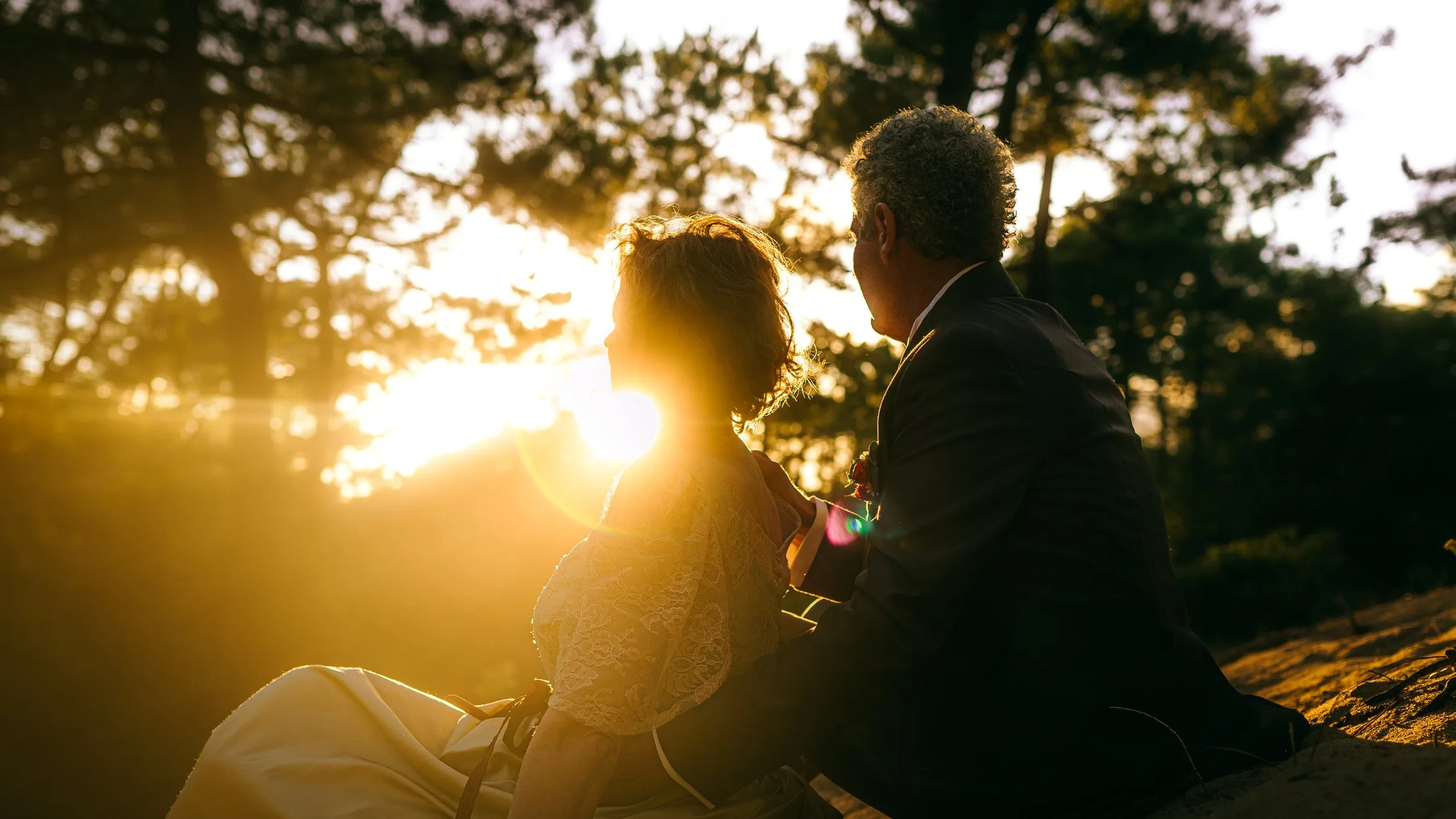 Le couple assis sous les pins au soleil couchant