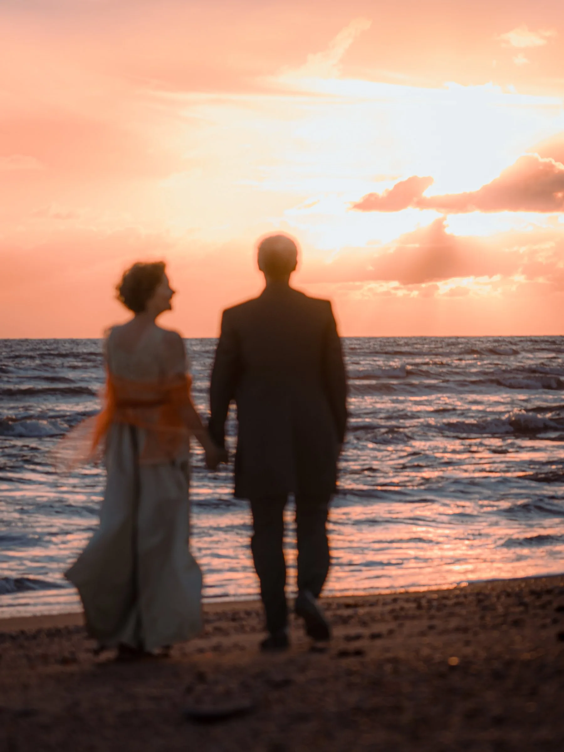 Le couple face à l’océan sous un ciel rose