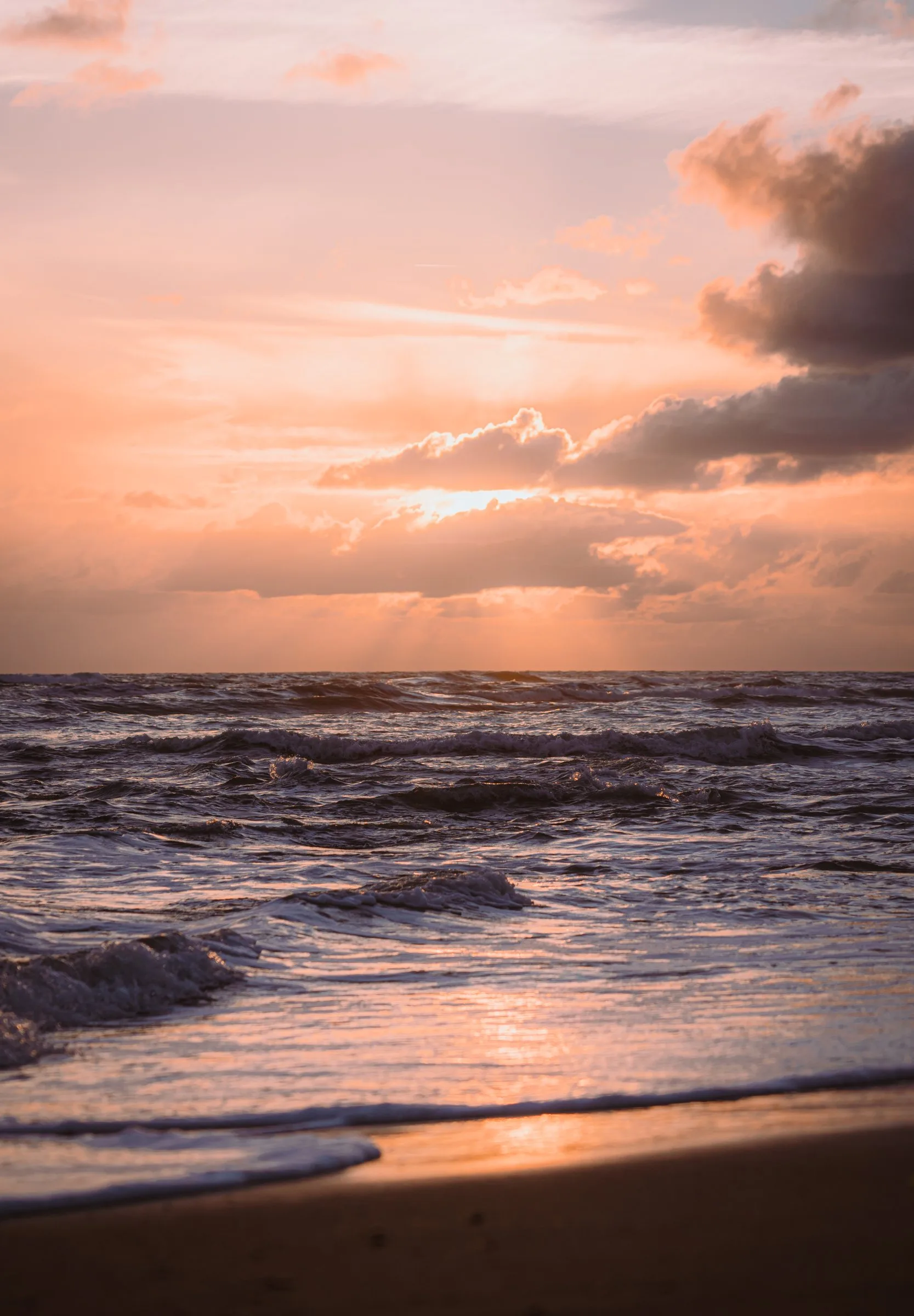 Les vagues sous un ciel rose au coucher du soleil