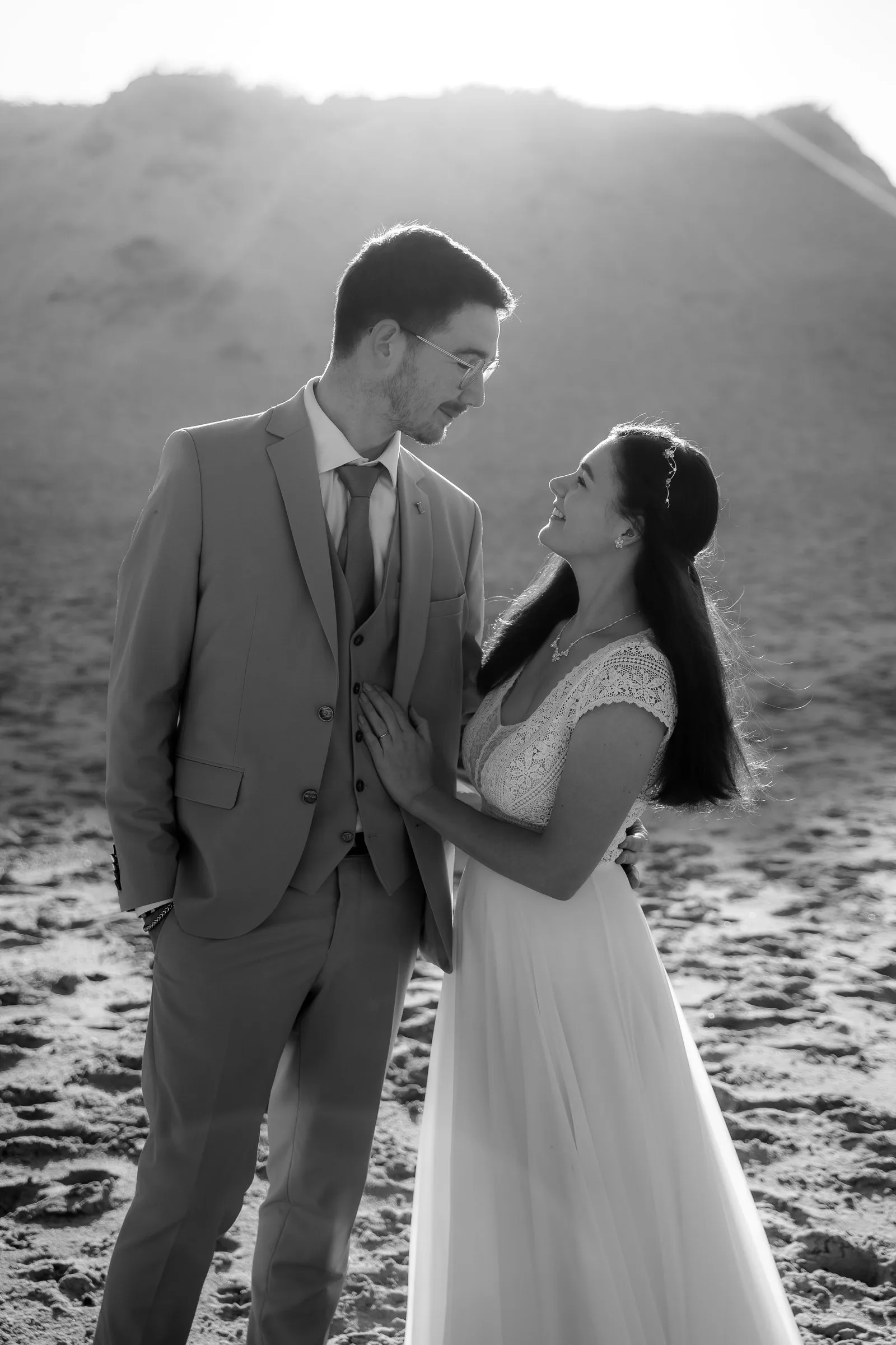 Regard complice dans les dunes, à contre-jour, en noir et blanc